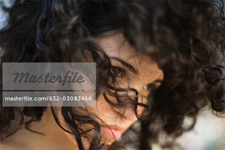 Young woman with tousled hair looking away, close-up
