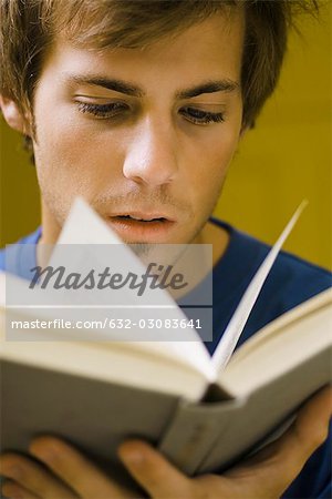 Young man reading book, close-up