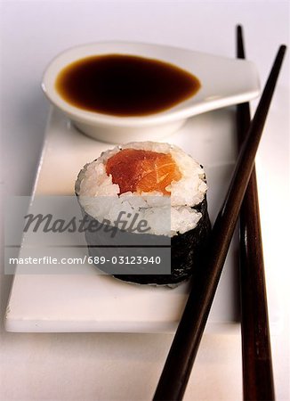 Maki-Sushi mit Lachs, Sojasauce und Stäbchen