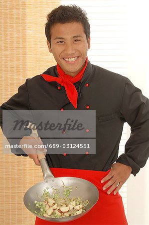 Asian cook with a peking pan