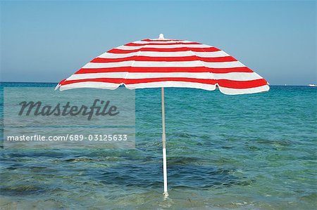 Parasol rouge et blanc dans l'eau