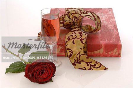 Arrangement de cadeaux, rose et verre de vin mousseux