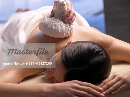 Woman getting a massage with a compress