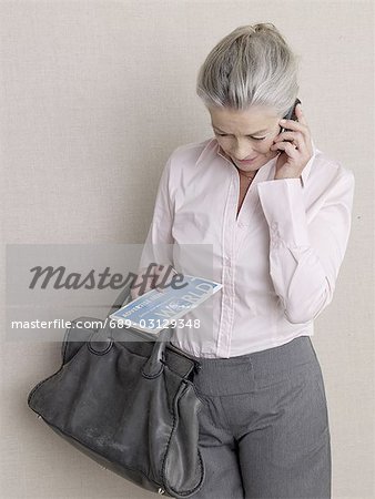 Senior adult in business clothing with laptop and credit card