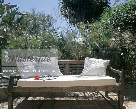 wooden bench with white cushions