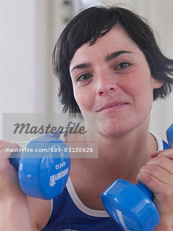 young woman with blue dumbbells