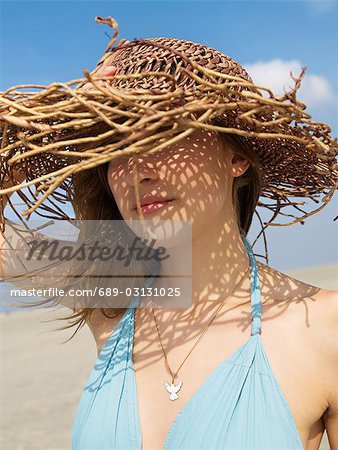 Woman with sun hat on the beach
