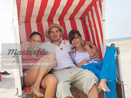 Three friends in a wicker beach chair