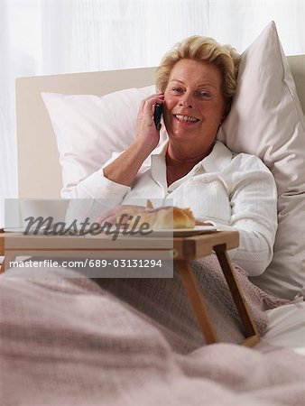 elderly lady with her mobile in bed