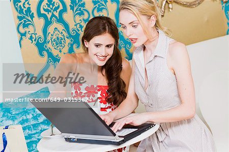 girls working on a laptop in a cafe