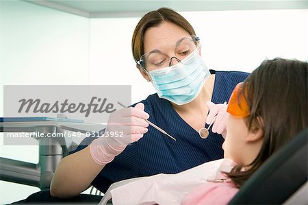Un femme dentiste traitant un patient