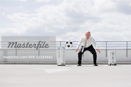 man playing football near car