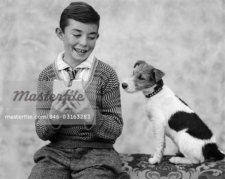 1920s 1930s BOY EATING SANDWICH AS DOG STARES AT FOOD