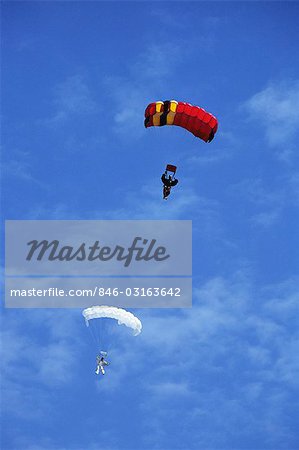 1980s TWO PEOPLE PARACHUTES OPEN AT END OF SKYDIVE