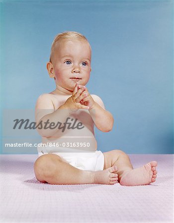 1960s BABY WEARING CLOTH DIAPER SITTING WITH HANDS TOGETHER THOUGHTFUL POSE EXPRESSION