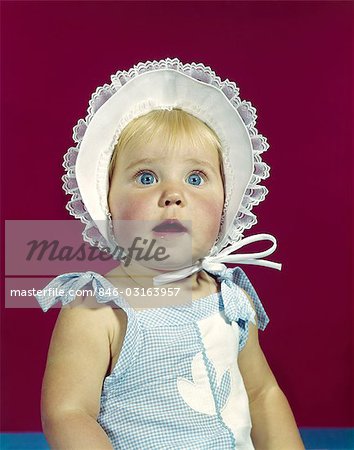 1960ER JAHRE BLONDE BABY BLUE EYES TRAGEN GEKRÄUSELTE HAUBE HUT GESICHTSAUSDRUCK DER WUNDER EHRFURCHT ÜBERRASCHUNG