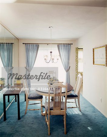 1970s DINING ROOM WITH DINING TABLE FOUR CHAIRS A CHANDELIER AND PALE BLUE CURTAINS