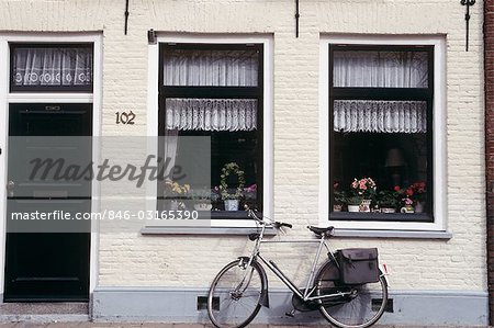 HOLLAND BICYCLE LEANING AGAINST APARTMENT BUILDING WALL