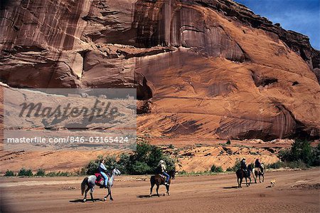 ARIZONA PEOPLE HORSEBACK RIDING THROUGH ANASAZI RUINS WITH NAVAJO GUIDE