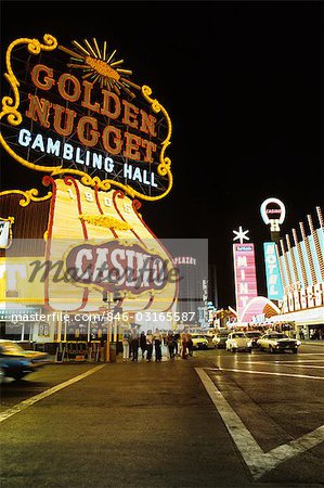 1970s FREMONT STREET DOWNTOWN LAS VEGAS NEVADA AT NIGHT WITH NEON OF GOLDEN NUGGET HORSESHOE AND MINT CASINOS