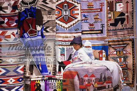 STREET VENDOR WITH BABY ON BACK SELLING CLOTH GOODS AT QUITO, ECUADOR