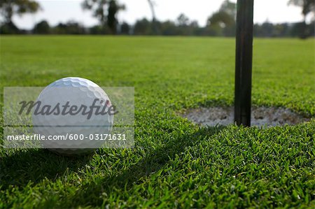 Close-up of Golf Ball Beside Hole