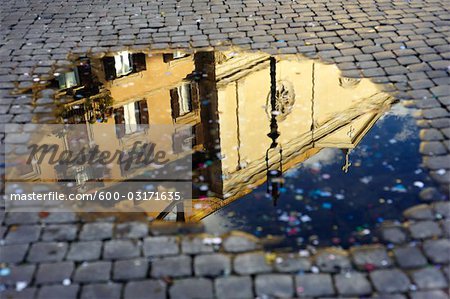 Konfetti und Reflexion der Gebäude in der Pfütze, Piazza Navona, Rom, Italien