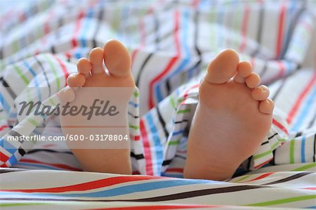 Close-up of Child's Feet in Bed