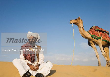 Man with a camel in a desert, Thar Desert, Jaisalmer, Rajasthan, India