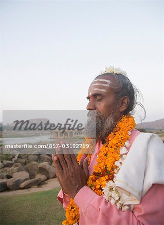 Sadhu standing in a prayer position, Hampi, Karnataka, India