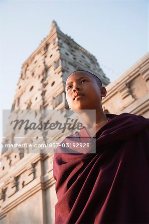 Low angle view of a monk day dreaming in front of a temple, Mahabodhi Temple, Bodhgaya, Gaya, Bihar, India