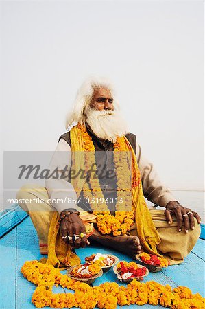 Sadhu sitting in a boat and praying, Ganges River, Varanasi, Uttar Pradesh, India