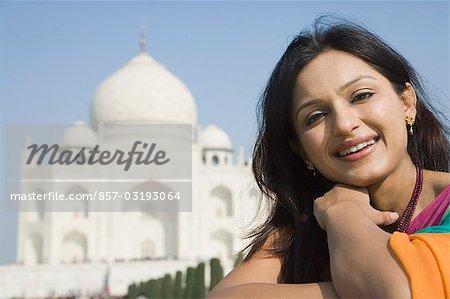 Woman smiling with a mausoleum in the background, Taj Mahal, Agra, Uttar Pradesh, India