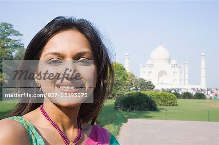 Gros plan d'une femme souriante avec un mausolée dans le fond, Taj Mahal, Agra, Uttar Pradesh, Inde