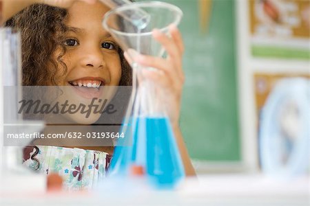 Little girl transferring liquid from test tube to beaker