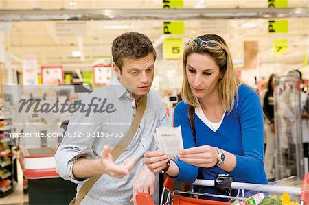 Couple reviewing sales receipt in store