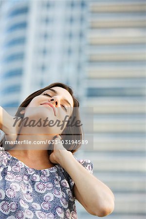 Woman massaging her neck, eyes closed