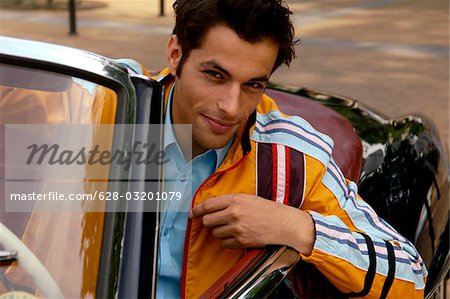 Junger Mann mit schwarzen Haaren in einem Auto sitzt und auf der Suche flirty, Nahaufnahme