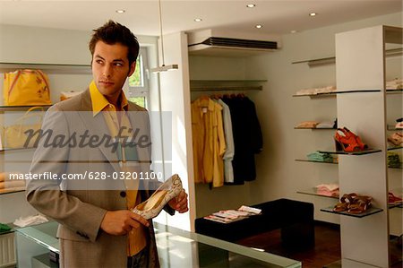 Young man with permanent de cheveux noirs dans un magasin de vêtements et est maintenant une orientation sélective à talons