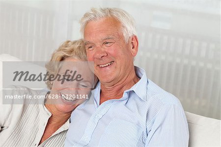 Heureux couple senior sur canapé