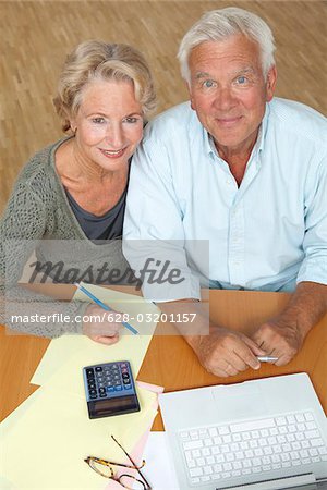 Senior couple using laptop and calculator