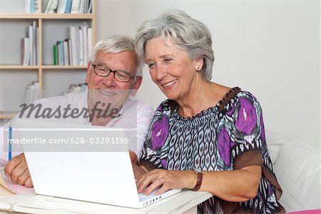 Happy senior couple using laptop