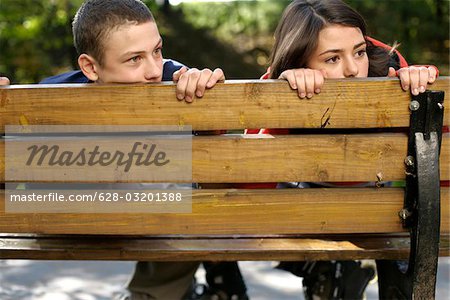 Teenage couple à la recherche sur le dos d'un banc