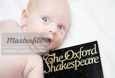 Baby lying beside a book, close-up, high angle view