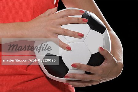 Femme tenant un ballon de football