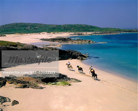 Vue grand angle de quatre personnes cheval sur la plage, Mannin Bay, Connemara, comté de Galway, Irlande