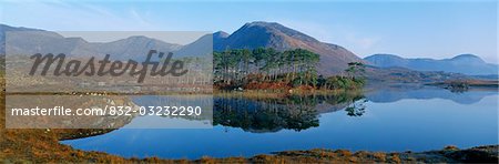 Reflection of trees and mountains in a lake, Derryclare Lough, Twelve Bens, Connemara, County Galway, Republic Of Ireland