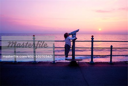 Jeune enfant, avec le télescope de bord de mer