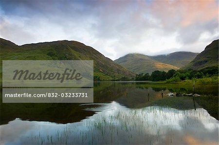 Fin Lough, Delphi vallée, Co Galway, Irlande ; Mweelrea et les collines de Sheeffry se reflètent dans le lac au lever du soleil