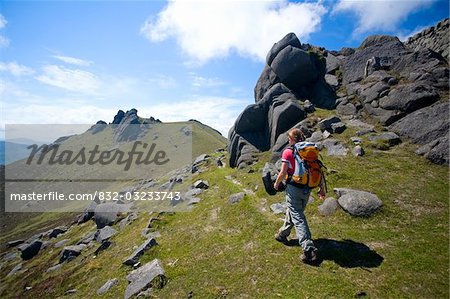Mourne Mountains, Co Down, Northern Ireland; Hiker passing the North Tor of Slieve Bearnagh